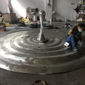 Large stainless steel sculpture surface finishing in the workshop
