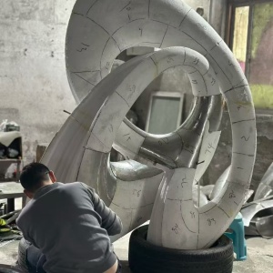 Curved stainless steel sculpture sections before polishing