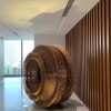 Installed bronze-tone stainless steel layered ring sculpture in a commercial interior