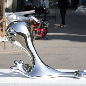 Reflective surface and curved-form detail on the same organic display sculpture