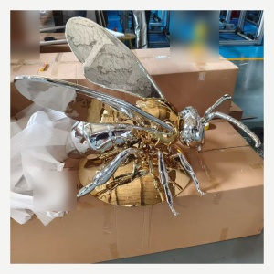 Top view of the same chrome and gold winged insect sculpture