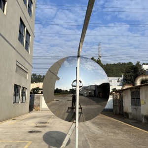 Side view of the same concave mirror stainless steel disc sculpture