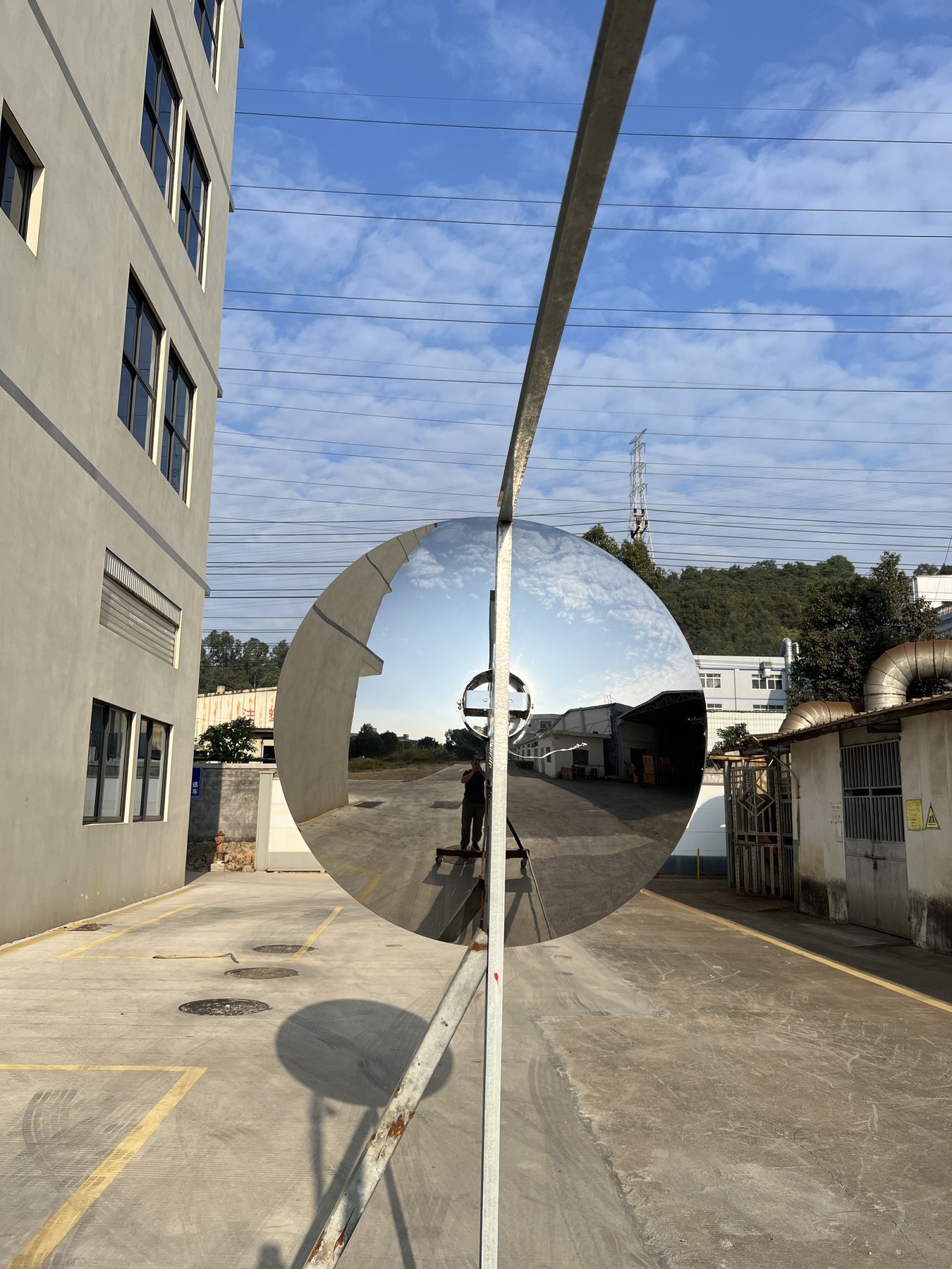 Side view of the same concave mirror stainless steel disc sculpture