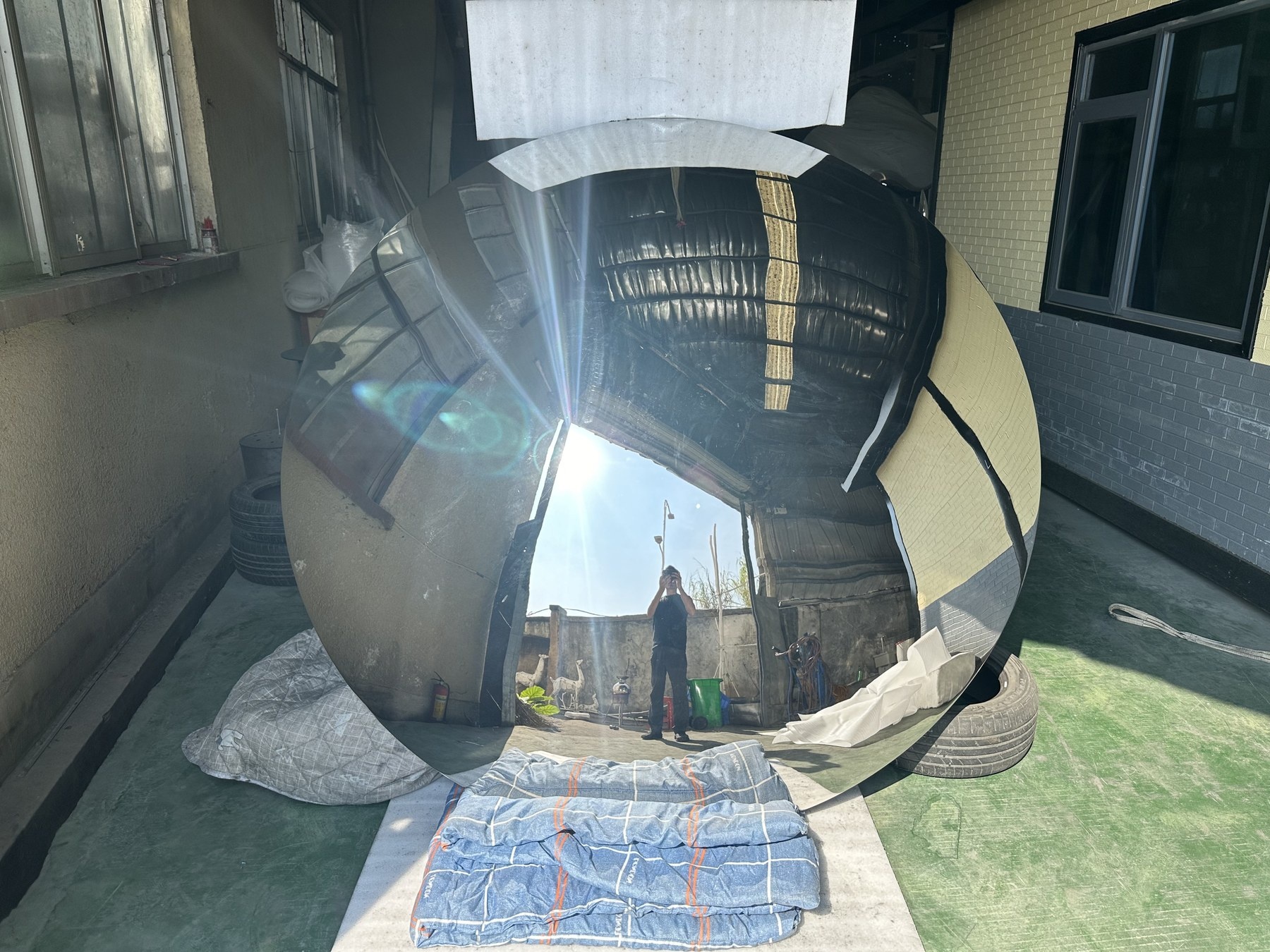 Large convex mirror stainless steel disc during final surface inspection