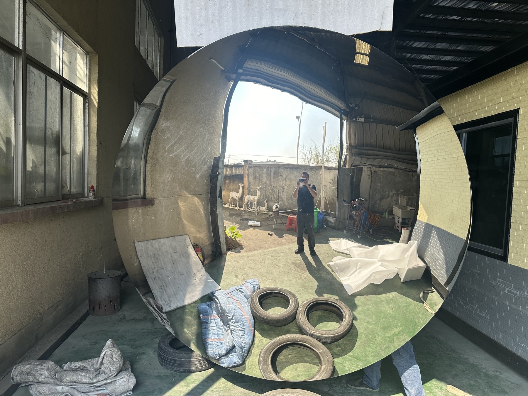 Close front view of the same convex mirror stainless steel sculpture