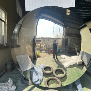 Close front view of the same convex mirror stainless steel sculpture