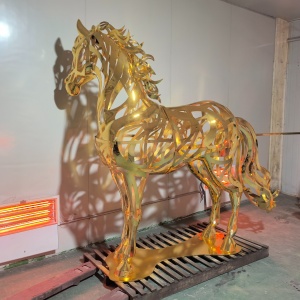 Side view of the same gold openwork stainless steel horse sculpture