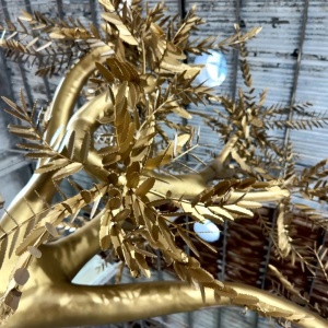 Golden stainless steel leaf and branch detail on the same tree sculpture