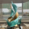 Completed green patina stainless steel leaf sculpture in a landscape installation setting