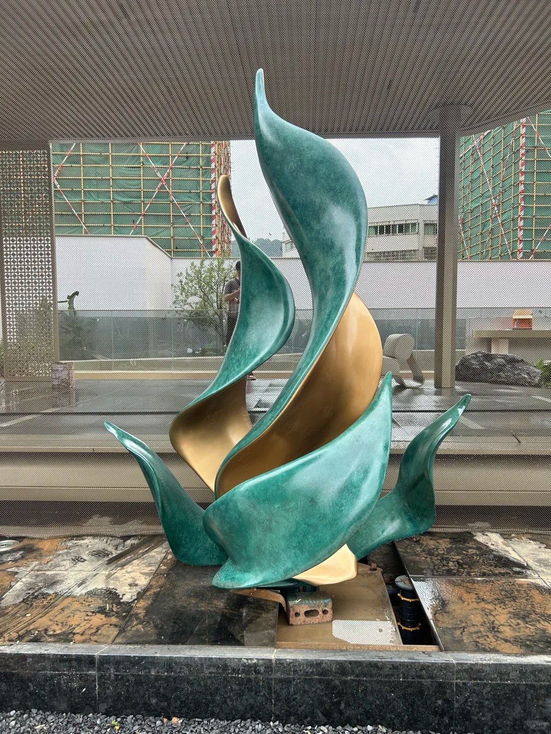 Second landscape setting view of the same green and bronze leaf sculpture