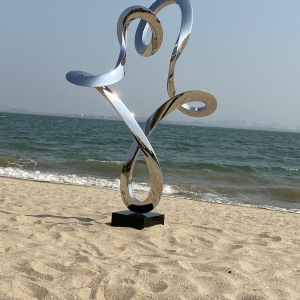Mirror stainless steel abstract figure sculpture in a coastal landscape