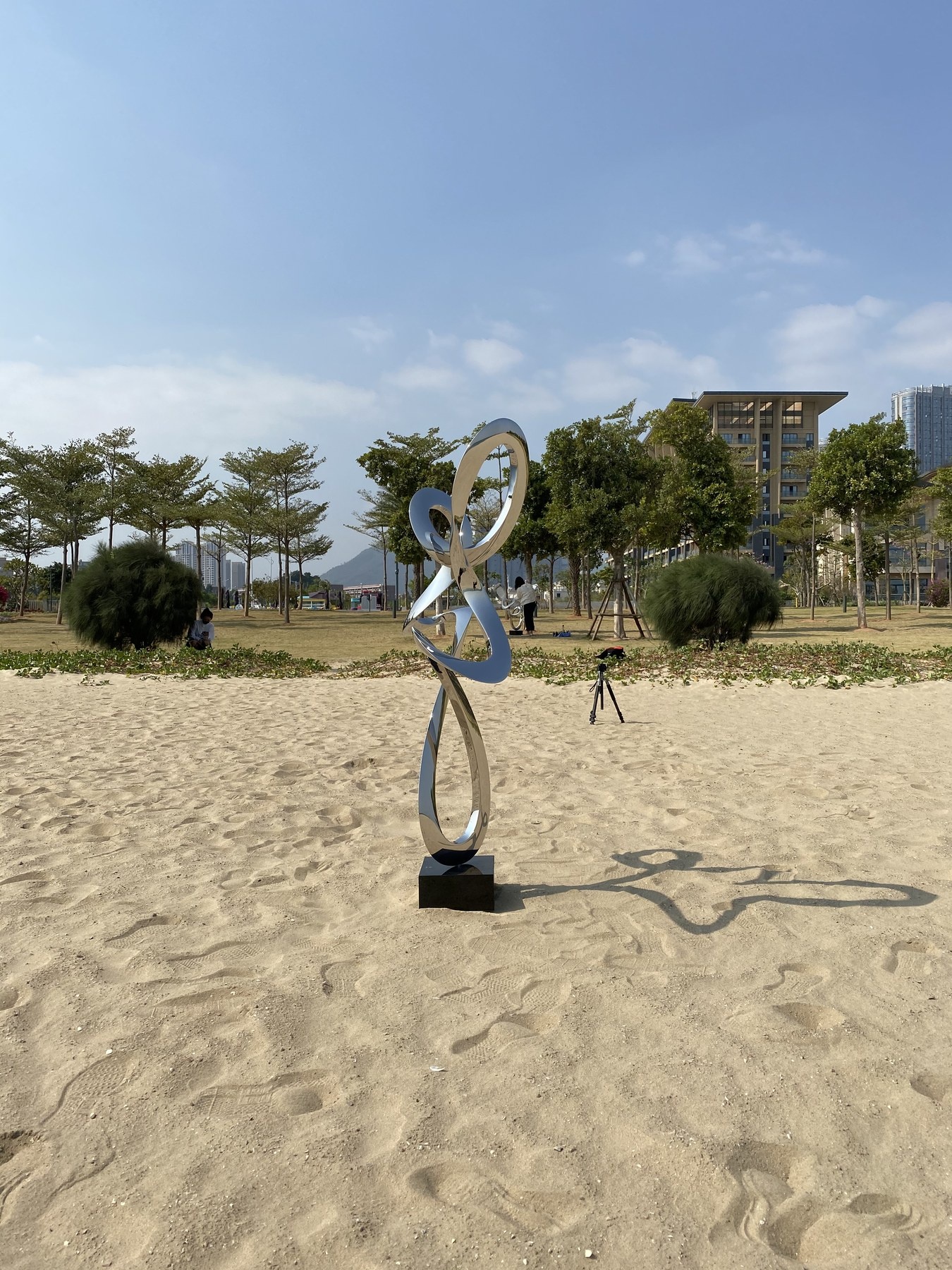 Rear angle of the same mirror stainless steel abstract figure sculpture