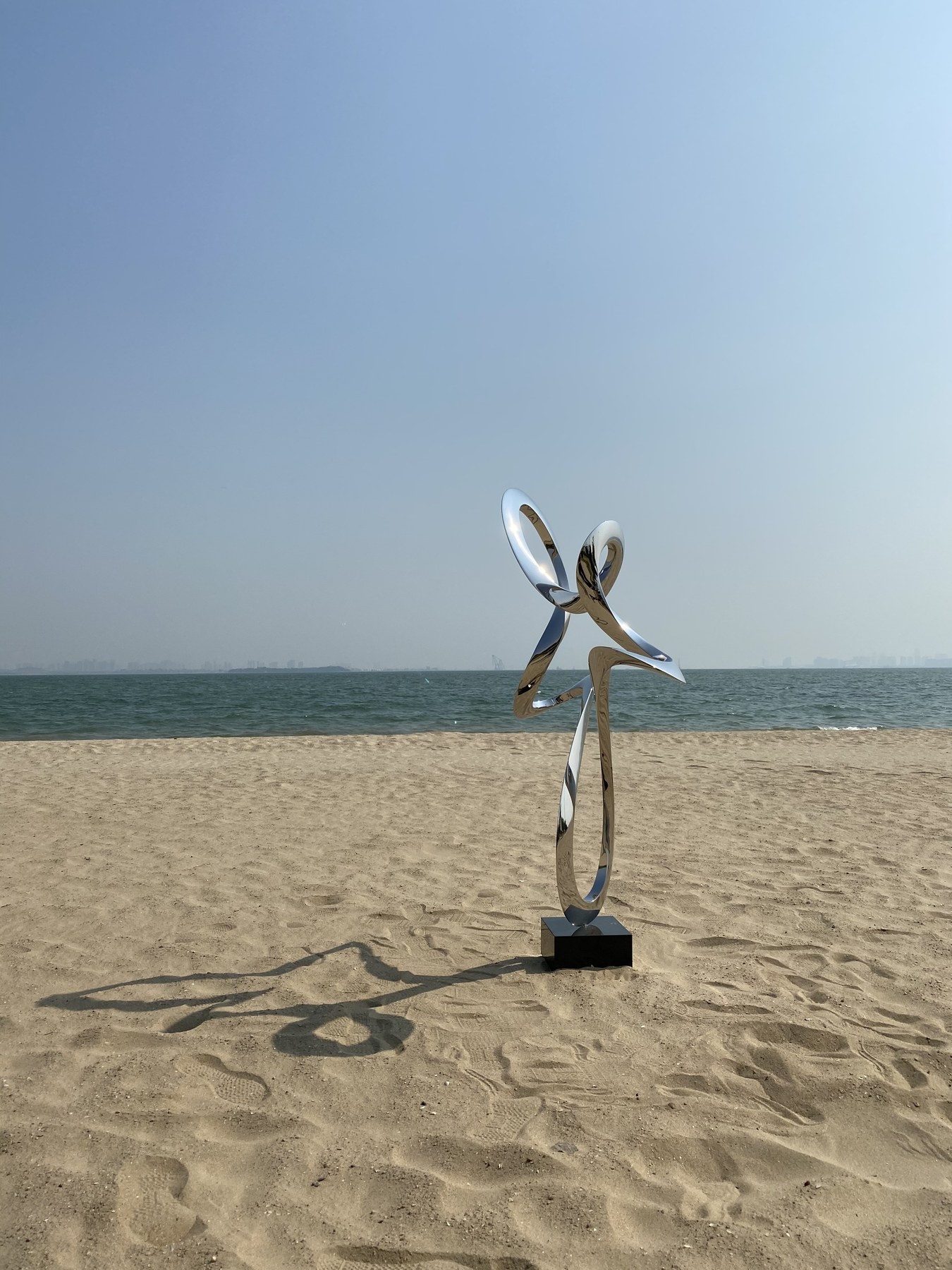 Side view of the same stainless steel ribbon sculpture