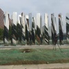 Mirror stainless steel vertical blade sculpture assembled in an outdoor staging area