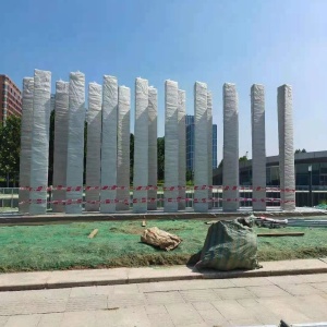 Wide project view of the same vertical blade sculpture during staging