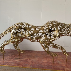 Side view of the same gold stainless steel leopard sculpture