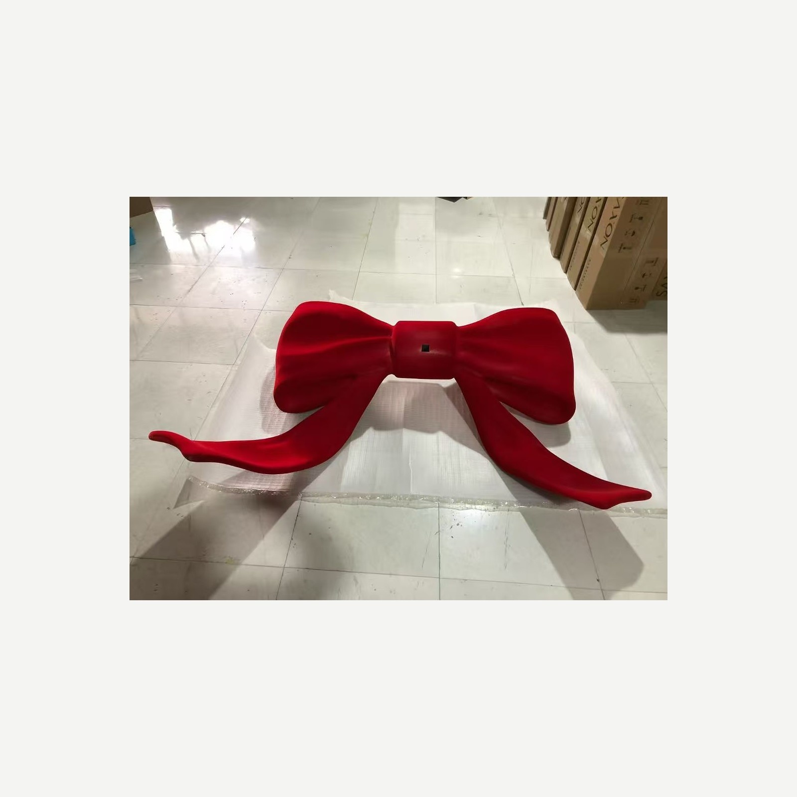 Completed oversized red bow display prop in the workshop