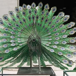 Painted metal peacock sculpture with open tail during workshop completion review