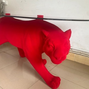 Side view of the same red flocked panther display table