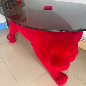 Flocked surface and glass-top detail on the same panther table