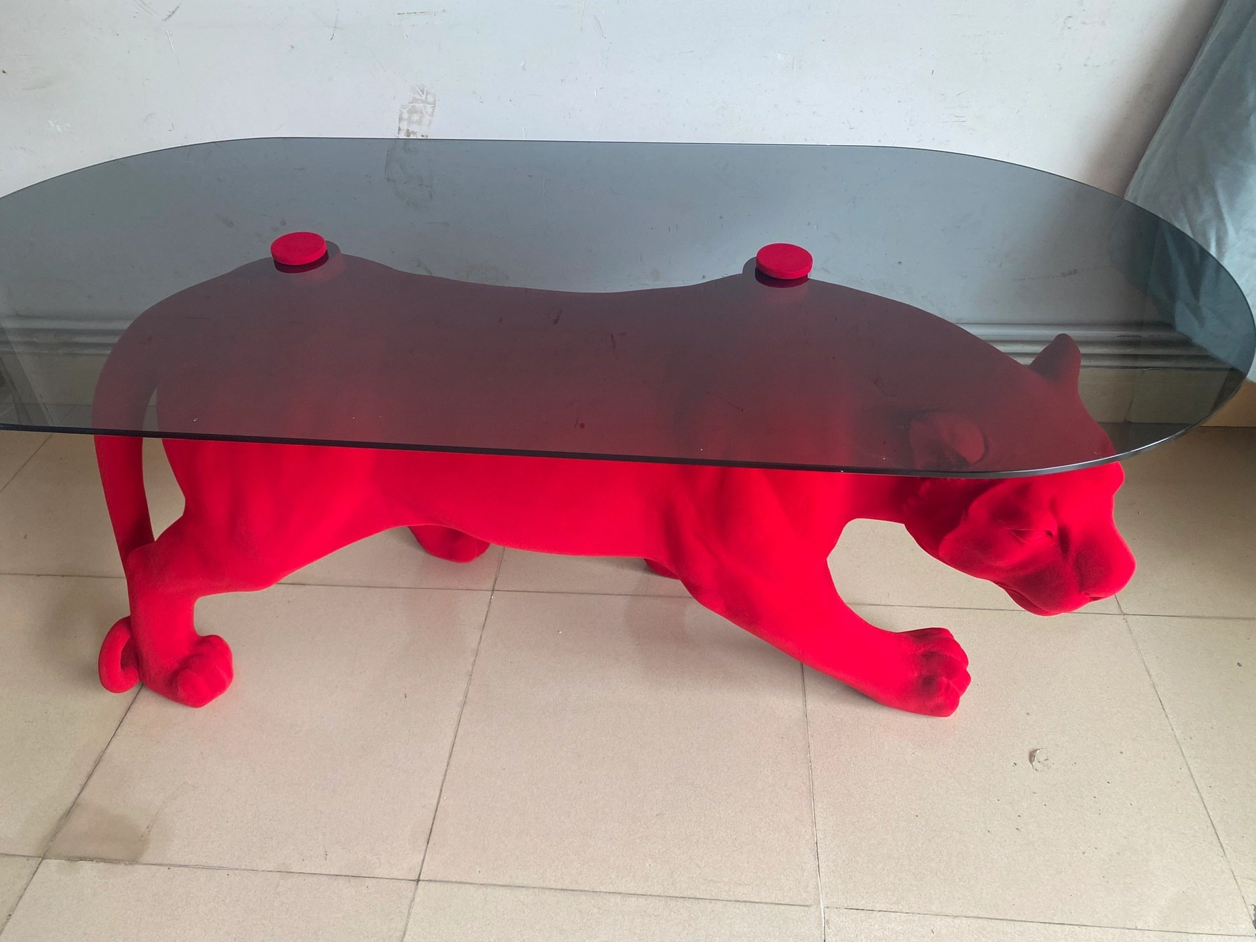 Rear three-quarter view of the same red flocked panther sculptural table
