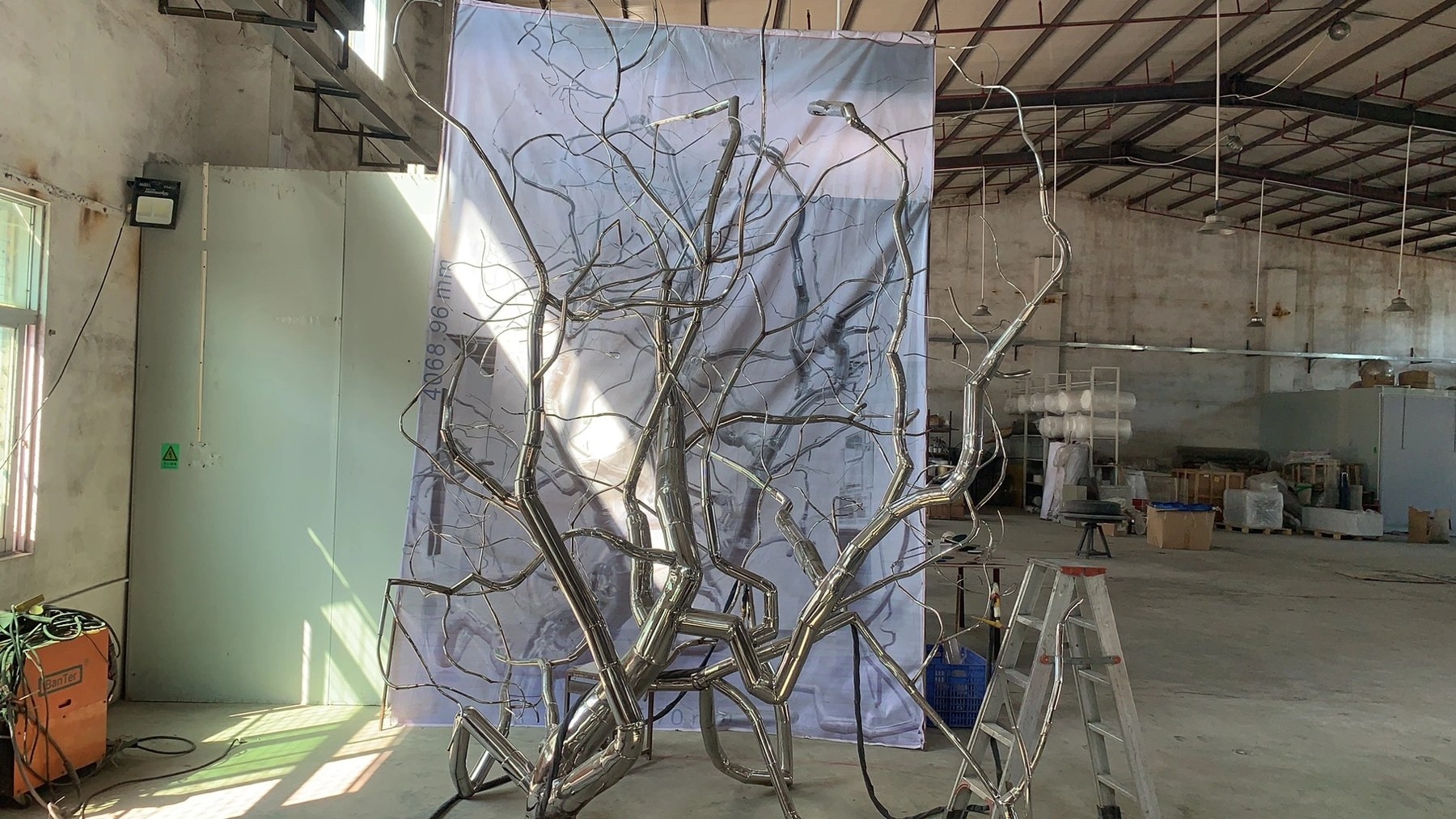 Workshop staging view of the same stainless steel branch sculpture