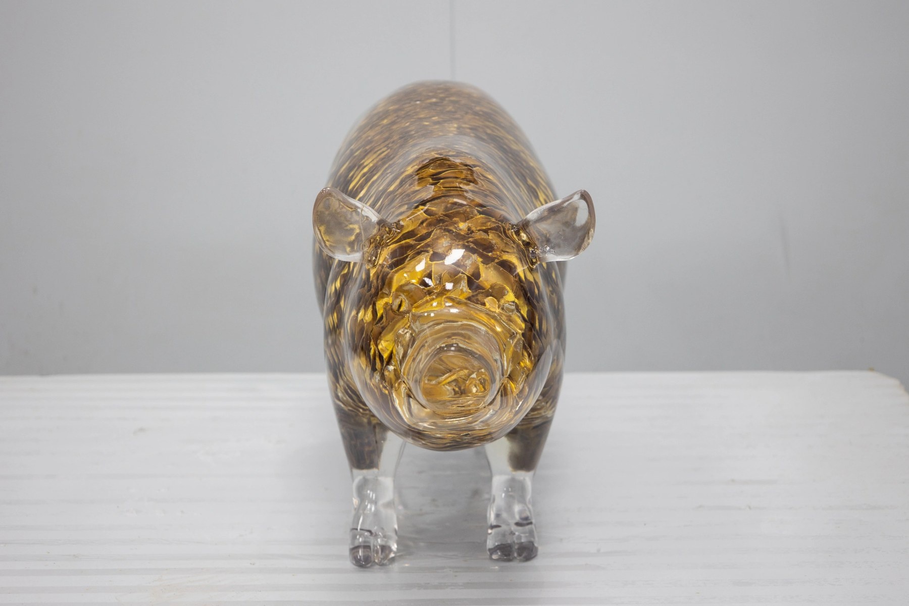Transparent golden openwork pig display sculpture front three-quarter view