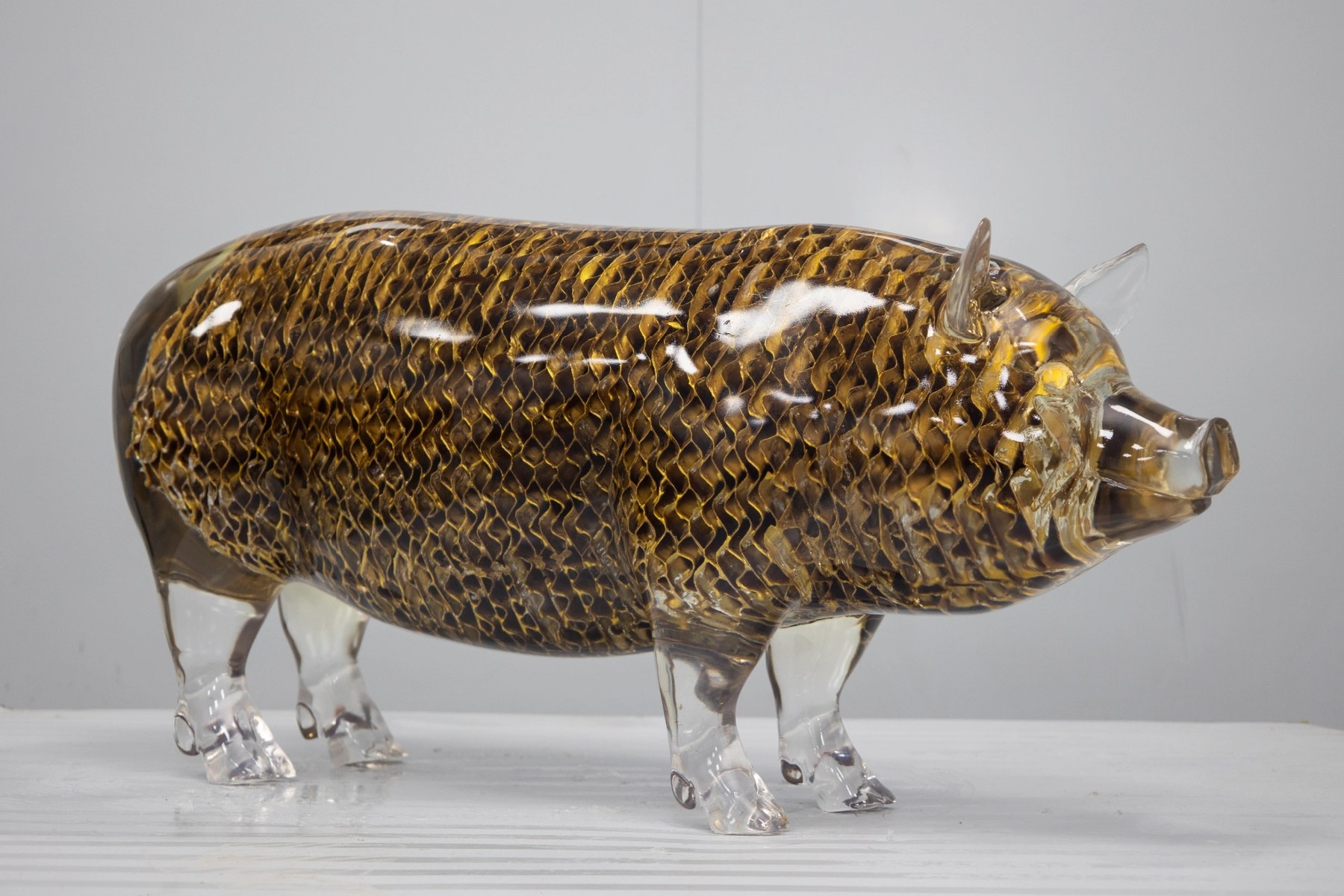 Side view of the same transparent openwork pig display sculpture