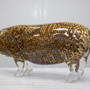 Openwork surface and transparent golden finish detail on the same pig sculpture